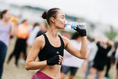 A participant drinking Akvilė water at an outdoor sporting event