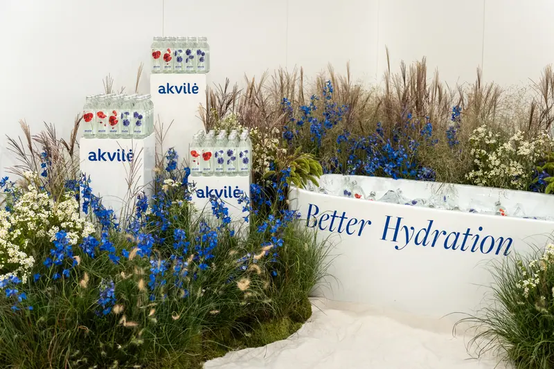An Akvilė event installation with cornflowers and floral glass bottles