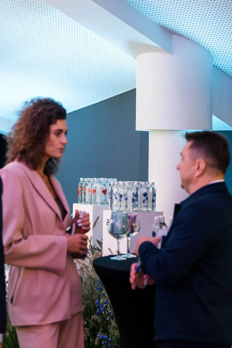 Guests talking beside an Akvilė display at an indoor event