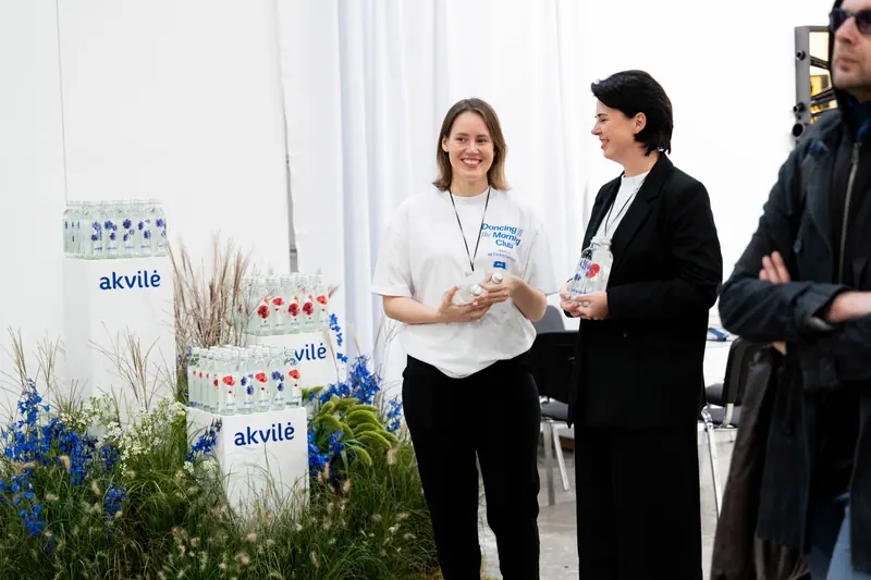 Two guests chatting beside a floral Akvilė installation