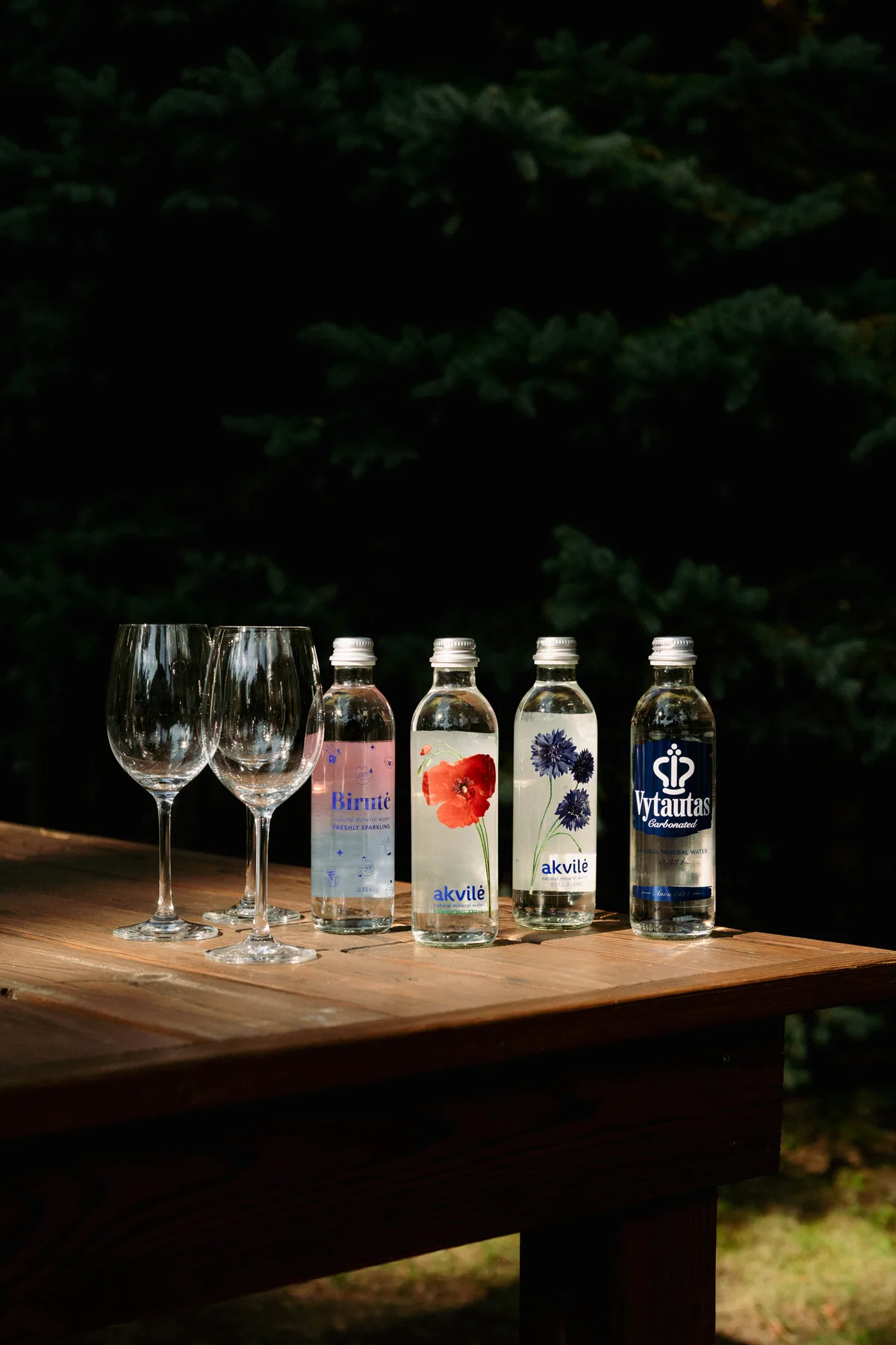 Akvilė floral glass bottles with stemware on an outdoor table