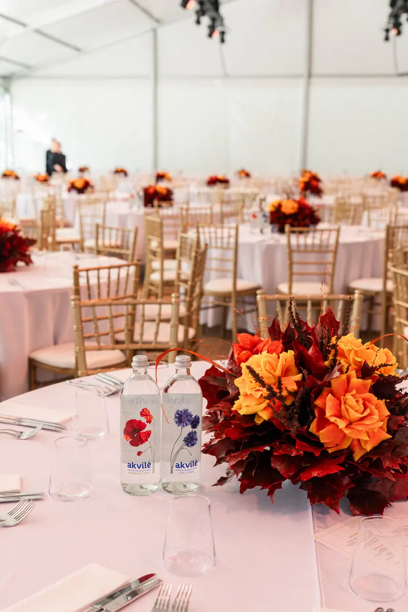 Glass water bottles and flowers on an elegantly set event table