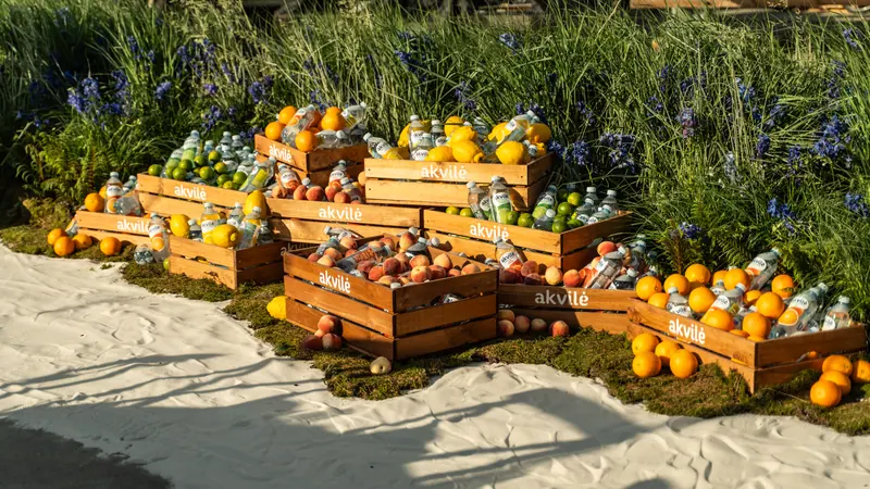 Fruit and Akvilė Bubbles arranged in wooden crates at an outdoor gathering
