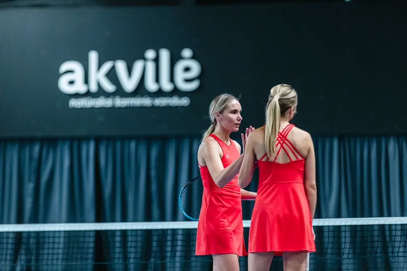 Two tennis players standing in front of an Akvilė backdrop