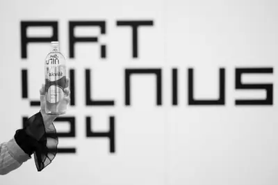 An Akvilė bottle held beside Art Vilnius 24 signage