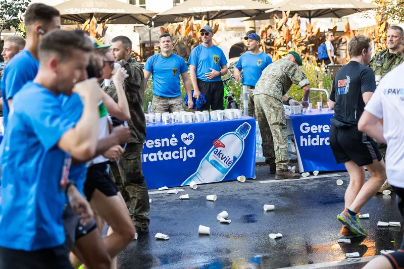 Runners passing the Akvilė refreshment station at a road race
